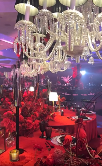 Crystal chandeliers above a red floral tablescape
