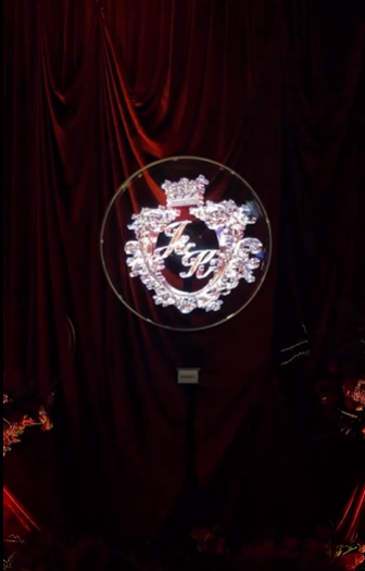 Illuminated monogram hoop on a draped backdrop